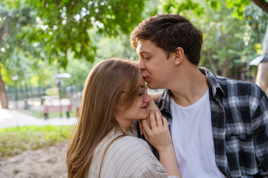 Young couple share tender moment in sunny park