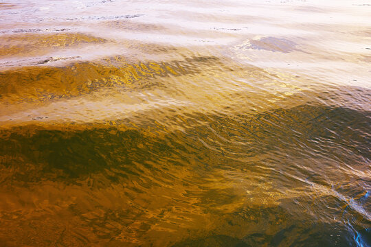 Sunlit water ripples at Helgoland dune beach, Germany