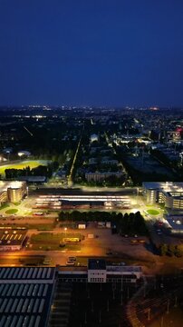 Nightfall Over Cityscape: An aerial view captures the sprawling cityscape at dusk, with illuminated streets, buildings, and a distant horizon under a deep blue sky.