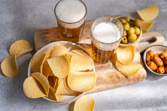 Beer and savory snack assortment on rustic wooden board