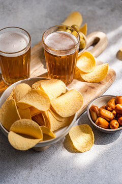 Beer and snack spread with chips olives and sausages