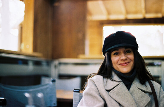 Smiling woman in winter coat at urban train station