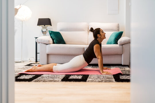 Woman practice yoga at home in a modern living room