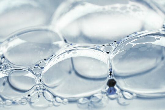 Macro view of translucent soap bubbles in blue water