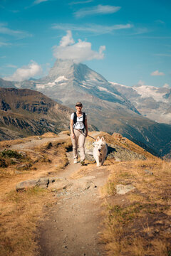 Woman hike with dog beneath Matterhorn near Zermatt