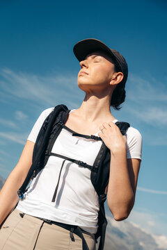 Female hiker with backpack under clear mountain sky