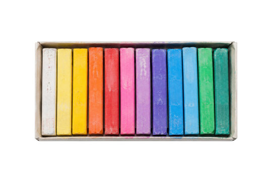Vibrant box of colorful pastel chalks, neatly arranged in a row, isolated on a clean white background