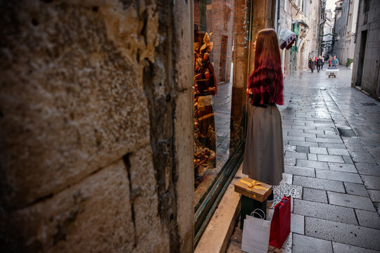 Woman shop for Christmas gift in historic town street