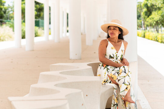 Mexican woman in floral dress relaxes at modern pavilion