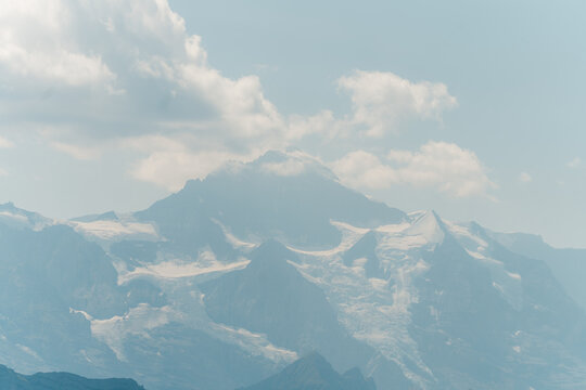 Snow-covered alpine peaks beneath clouds in Switzerland