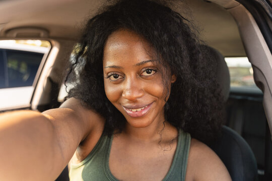 Woman take selfie inside parked car during daytime