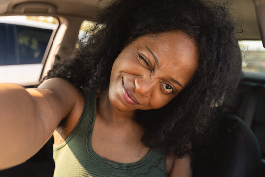 Woman wink and take selfie inside parked car
