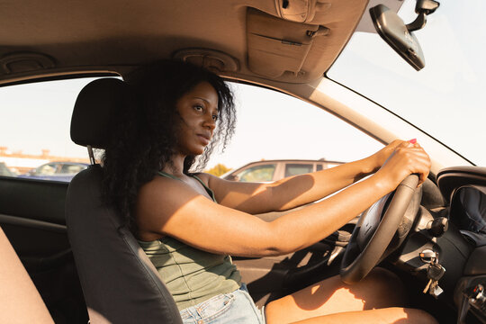 Woman driving car in sunlight during outdoor lifestyle trip