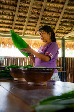 Amazonian woman prepare ancestral maito food with leaf