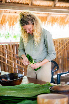 Woman prepare maito with banana leaf in amazon shelter