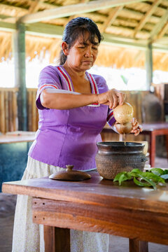 Indigenous woman prepare ancestral food in Amazonian kitchen