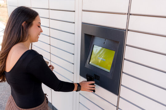 Woman send package using automated parcel locker