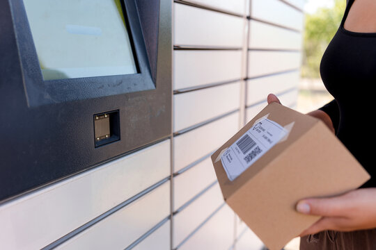 Woman use parcel locker for package pickup