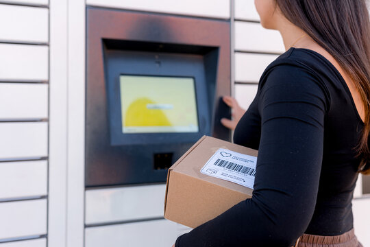 Woman send package through parcel locker at gas station