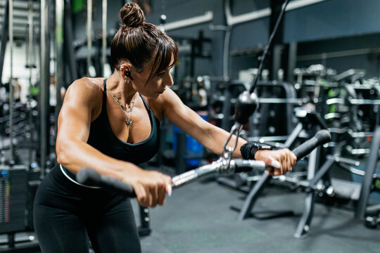 Woman perform cable exercise at modern gym