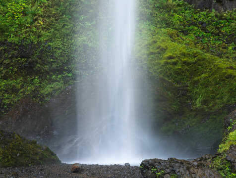 Water cascades into the rocky pool at the base of Lower Latourell Falls within Guy W. Talbot State Park in Oregon.