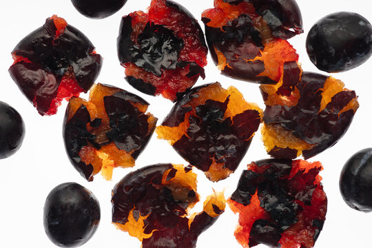Crushed black grape with colorful pulp on white background