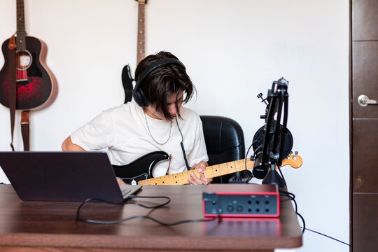Music compositor recording electric guitar in home studio