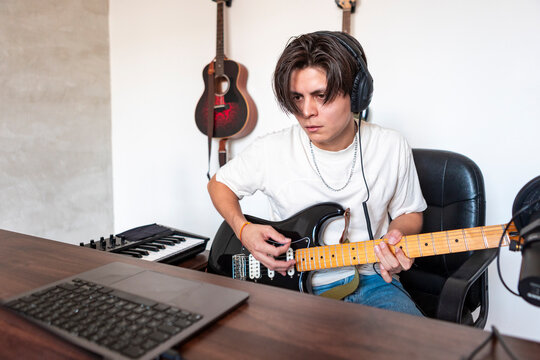 Young musician compose guitar music in home studio
