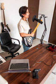 Musician record electric guitar vocals in home studio