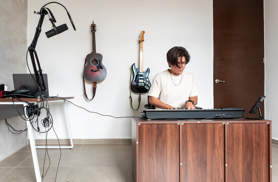 Music compositor play keyboard in home recording studio