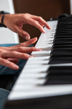 Hands play piano keys in close-up musical performance