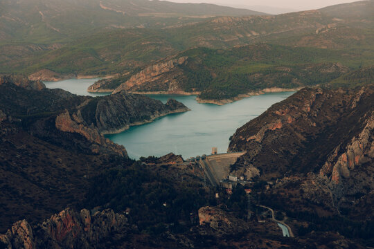 Reservoir landscape with dam between rugged mountain cliffs