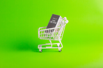 Side view of fine silver bullion bar inside white shopping cart on green background for wealth investment.  © wibiwisnu