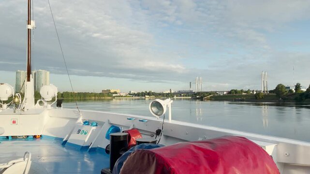 A cruise ship sails peacefully along the Neva River. Passengers feel happy and relaxed enjoying the serene views of Saint Petersburg.