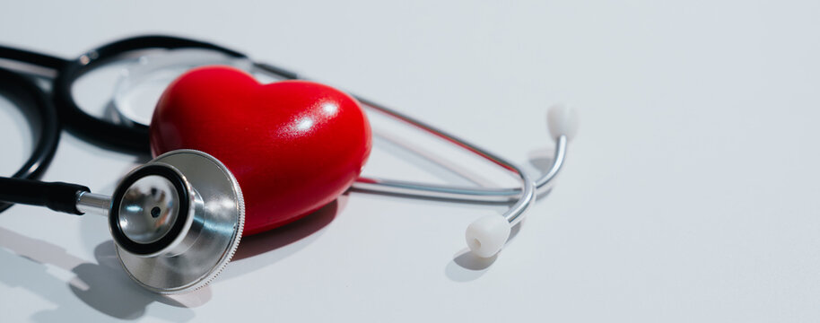 Stethoscope and red heart symbolize healthy life, cardiology care, and medical examination, showing optimistic medical emotion