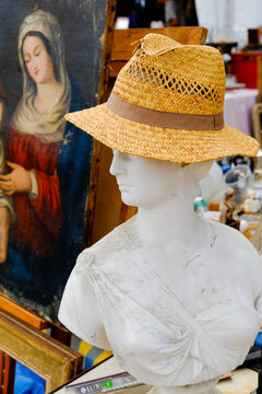 Mannequin bust wearing straw hat at a Paris flea market