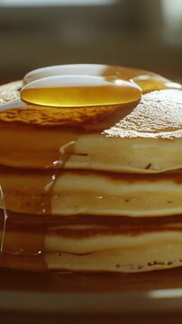 A stack of fluffy pancakes resting on a clean white plate, ready to be devoured