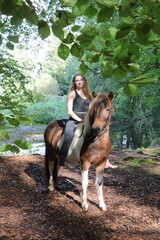 Junge attraktive Reiterin mit Pferd im Wald © Bittner KAUFBILD.de