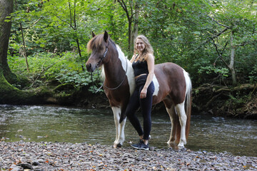 Junge attraktive Reiterin mit Pferd im Wald © Bittner KAUFBILD.de