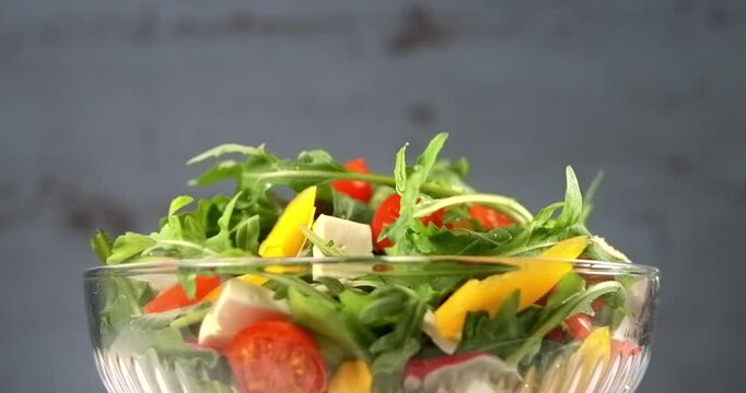 Fresh vegetable salad with arugula tomato pepper and white cheese
