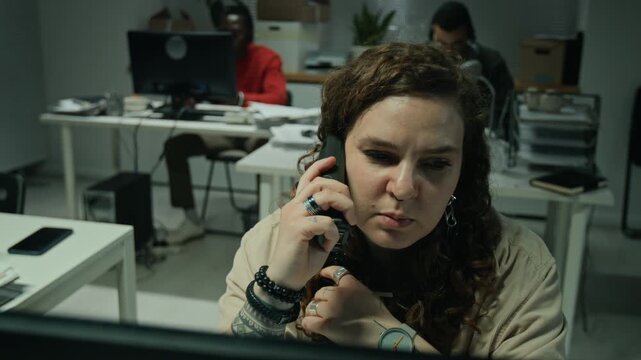 Caucasian young woman switching from radio to headset, answering client calls on computer in office. Footage suits call center campaigns, customer service and tech support marketing