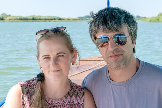 Close up portrait of couple on boat tour along Ochakiv distributary in Danube Delta, Ukraine. Summer vacation, travel and relationship concept