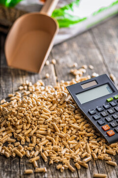 Wood Pellets And Calculator On Table Representing Biofuel Heating Costs And Renewable Energy Budgeting