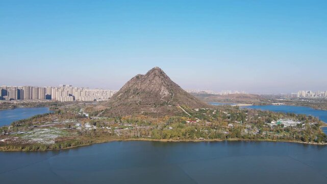 Aerial View of Huashan Mountain and Lake Surrounded by City Skyline in Jinan, China