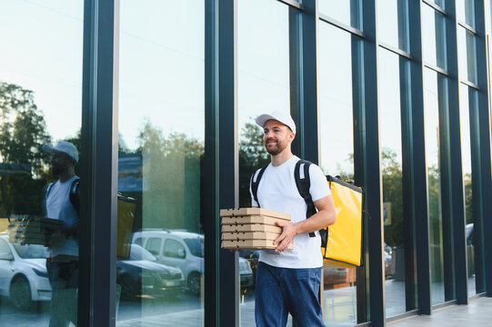 Courier delivering pizza boxes walking in city