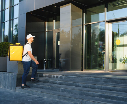 Food courier delivering order to modern office building