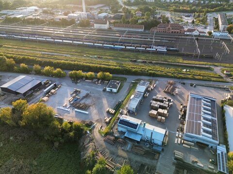 Lumber factory with rooftop solar panels and cargo trains