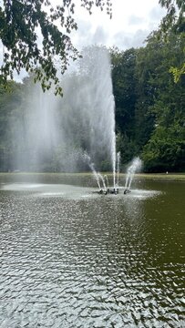 Fontaine et son embrun par le vent &agrave; la pi&egrave;ce d'eau du parc de la Dodaine &agrave; Nivelles (Brabant-Wallon)