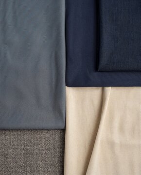 Various fabric textures in neutral and dark colors arranged together  