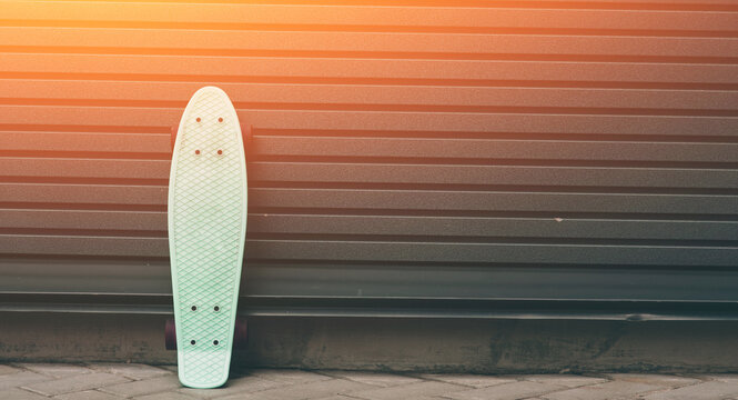 a skateboard leaning against wall, empty space at the right for custom text